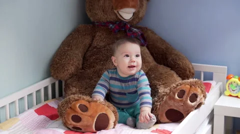 Pretty child sitting at the bed with his teddybear and plays with it while has f Stock Footage 62083082