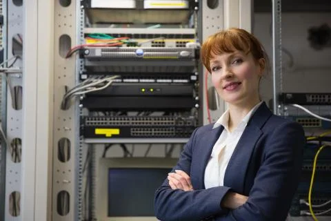 Pretty computer technician smiling at camera while fixing server Stock Photos