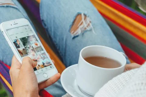 Pretty content creator in hammock use smartphone look at screen chat in socia Stock Photos