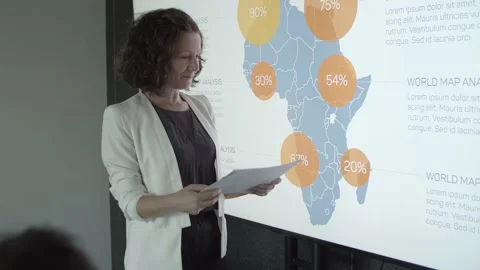 Pretty content manager pointing at map and talking Stock Footage 137512268