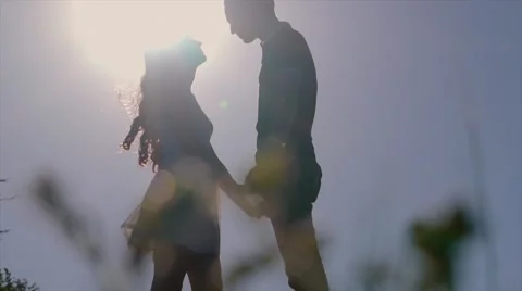 Pretty couple in the meadow on the sunset background Vídeos de archivo 64017886