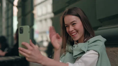 Pretty deaf having video call on cell phone at cafe terrace Stock Footage 161037655