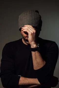Pretty dramatic man looking away while standing against black studio background Stock Photos