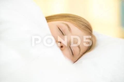 The pretty face of the young girl on the pillow Stock Photos