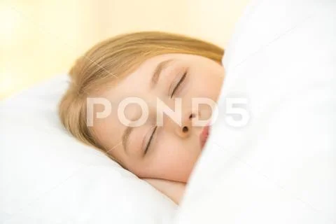 The pretty face of the young girl on the pillow Stock Photos