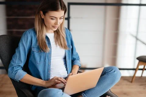 Pretty fair-haired lady working on her laptop at home Stock Photos