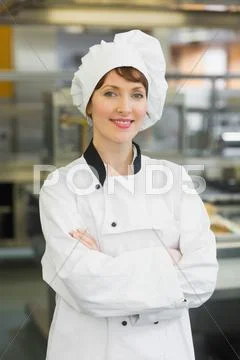 Pretty female chef posing in a modern kitchen Stock-Fotos