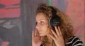 Pretty Female with Curly Hair and Headphones Listening Music. HD Footage