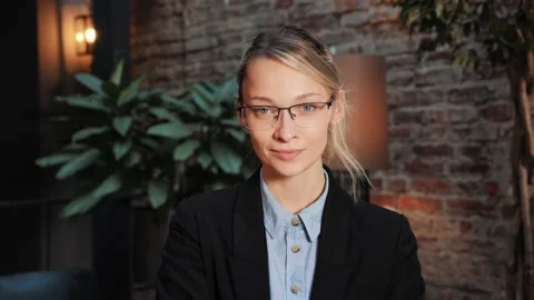 Pretty female face looking at camera posing alone at office place. Stock Footage 232476009