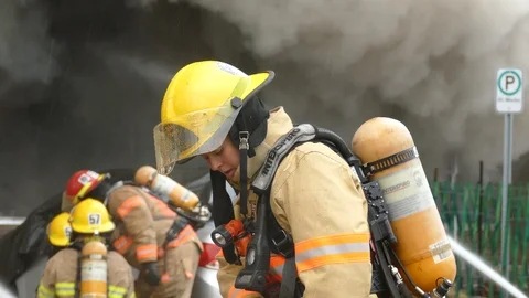 Pretty female firefighter pulling off and removing helmet at fire Video stock 127251557