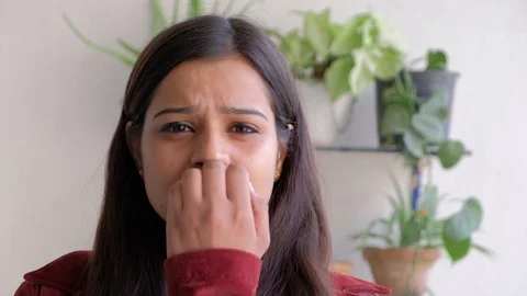 Pretty female looks at the camera bites her nails as she tries to think and come Stock Footage 101279964