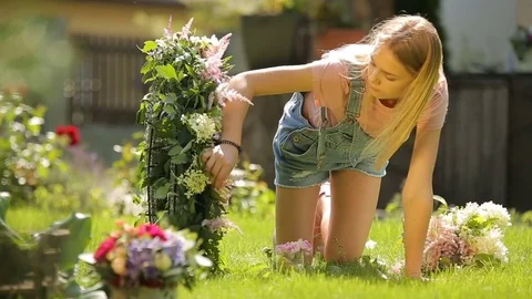 Pretty female model blond smiling girl making a tender floral composition from Stock Footage 83570013