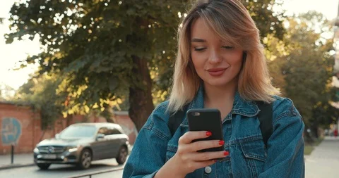 Pretty female model posing on Camera with her Mobile Phone, Standing in the City Stock Footage 121009342