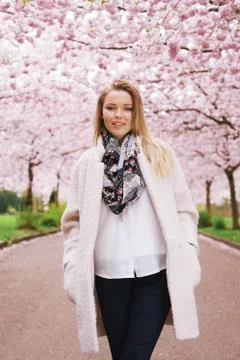 Pretty female model posing at spring blossom garden Stock Photos