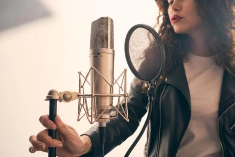 Pretty female singer recording in music studio Stock Photos