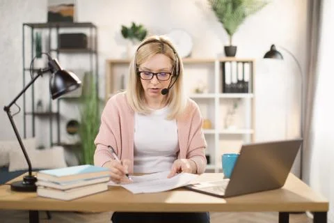 Pretty female software developer using modern laptop for remote work at home. Stock Photos