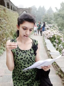 Pretty female student reading while walking. Stock Photos