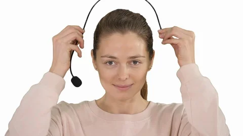 Pretty female support center operator with headset smiling to camera on white Vídeo Stock 108600796