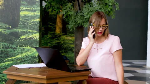 Pretty female talks on smartphone solving work problems Stock Footage 141071104