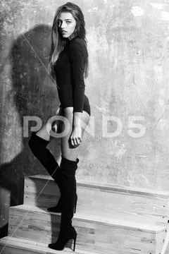 Pretty girl in black bodysuit and stylish knee high boots Stock Photos