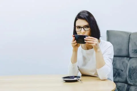Pretty girl in cafe drinks coffee Stock Photos