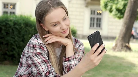 Pretty girl in checked shirt doing selfi... | Stock Video | Pond5