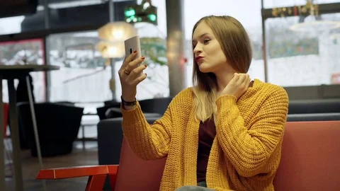Pretty girl checking her appearance in smartphone and smiling to the camera Stock Footage 71847904
