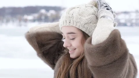 Pretty girl correcting and posing with hat in winter day Vídeo Stock 70344484