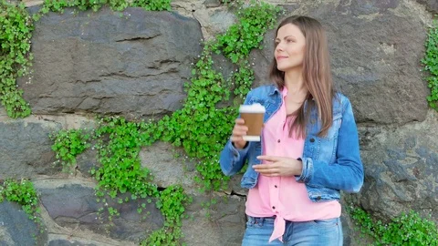 Pretty girl in a cotton jacket drinking coffee.  Stock Footage 80025209