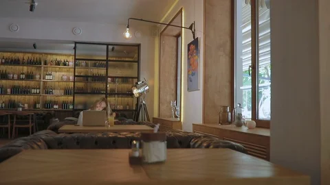 Pretty girl dances sitting in front of computer in cafe Stock Footage 102084643