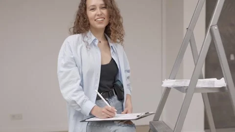 Pretty girl designer keeps documents while standing at her workplace Stock Footage 330535111