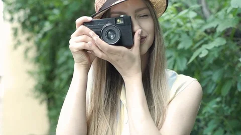 Pretty girl doing photos on old camera and smiling, steadycam shot Stock Footage