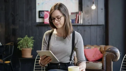 Pretty Girl Drinking Coffee In A Coffee Shop Looking At Her Tablet Smiling Stock Footage
