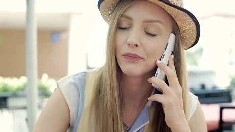 Pretty girl eating dessert in the cafe's garden and chatting on cellphone, stead Stock Footage