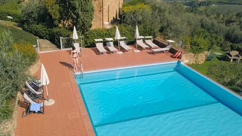 Pretty girl getting out of pool after swimming on sunny day aerial view Video stock 105437778