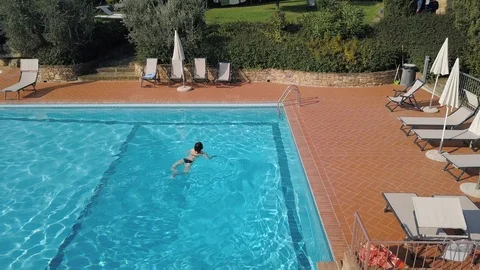 Pretty girl getting out of pool after swimming on sunny day aerial view Stock-Footage 105437824