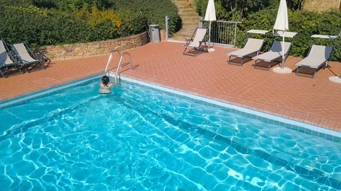 Pretty girl getting out of pool after swimming on sunny day aerial view Vídeo Stock 105437956