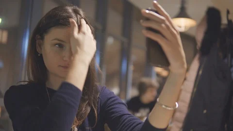 Pretty girl having fun while doing selfies on mobile in the cafe. Stock Footage 88475063