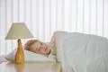 The pretty girl lay on the bed with white linens Photo