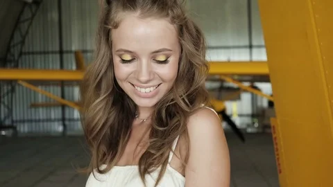 Pretty girl looking at camera and smiling. Girl on airfield. Stock Footage 76984083