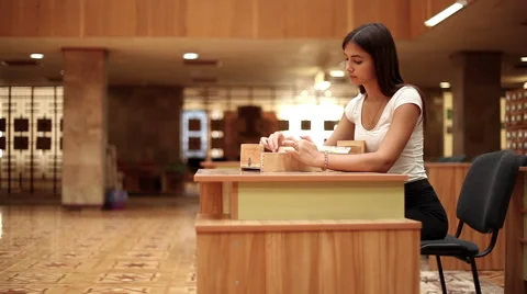 Pretty girl looking on catalog on the table in a library 1 動画素材 66481859