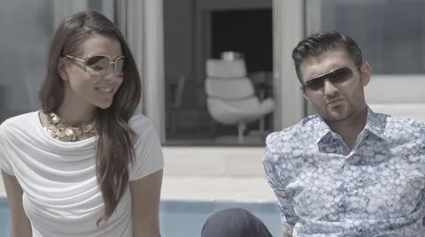 Pretty girl man model posing to camera both sunglasses sat down Stock Footage 68709385