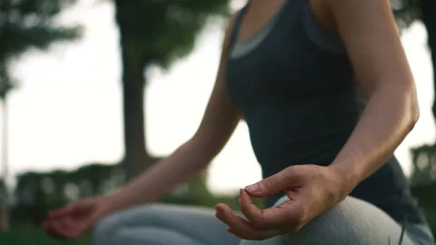 Pretty girl meditating while sitting in lotus pose. Yoga practicing in park Video stock 97744892