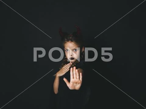 Pretty girl with red halloween horns and cape Stock Photos