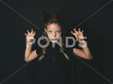 Pretty girl with red halloween horns and cape Stock Photos