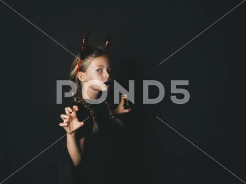 Pretty girl with red halloween horns and cape Stock Photos