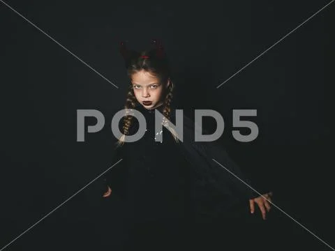 Pretty girl with red halloween horns and cape Stock Photos