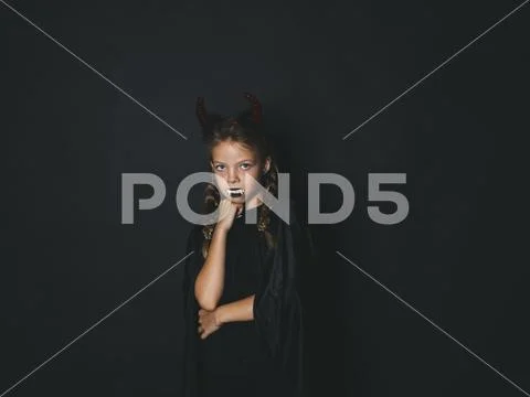 Pretty girl with red halloween horns and cape Stock Photos