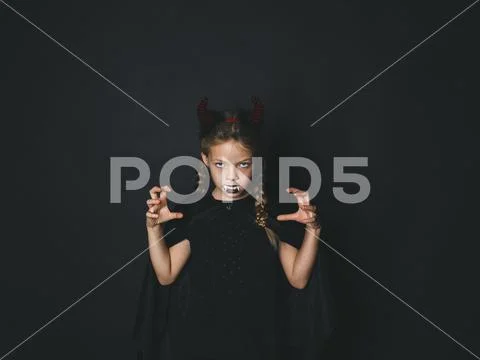 Pretty girl with red halloween horns and cape Stock Photos