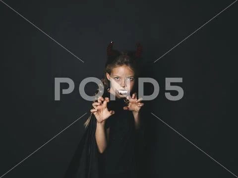 Pretty girl with red halloween horns and cape Stock Photos
